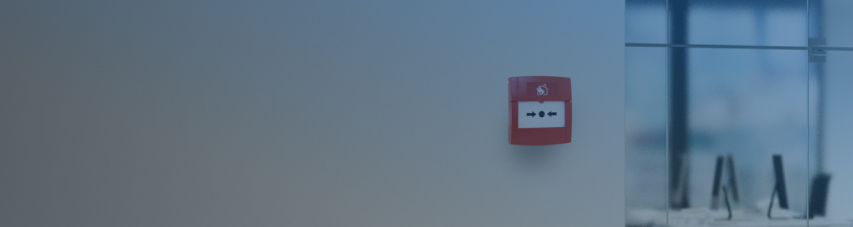 A callpoint unit on a wall outside an office suite, overlaid with a blue gradient